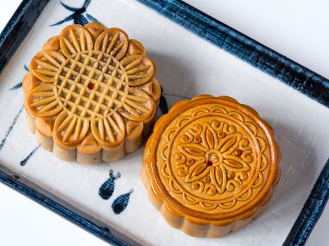 Mid autumn festival dessert, flower pattern moon cakes in white plate on white background