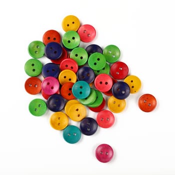 Mix of assorted colorful multicolor round painted wooden handmade sewing buttons over white background, close up, elevated top view