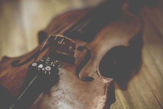 Vintage old violin lying on a wooden surface