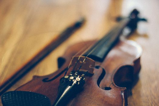 Vintage old violin lying on a wooden surface