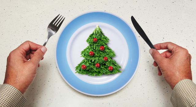 tableware in hands and holiday salad on a plate
