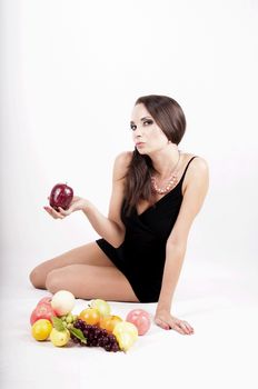 Portrait of slim fitness cheerful girl lying in studio with set of fruit and vegetables over white background. Healthy eating, diet, fitness, weight lose concept.