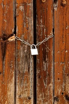 Closeup shot of padlock on the old wooden gates
