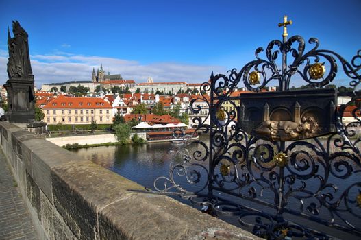 Panoramic view on St. Vitus Cathedral from Charles Bridge with Statues of Saints Norbert, Wenceslaus and Sigismund and bronze relief for good luck in Prague, Czech Republic