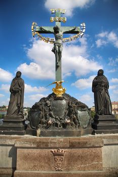 Statuary of the St. Cross with Calvary on the Charles Bridge (Karluv Most) in Prague, Czech Republic