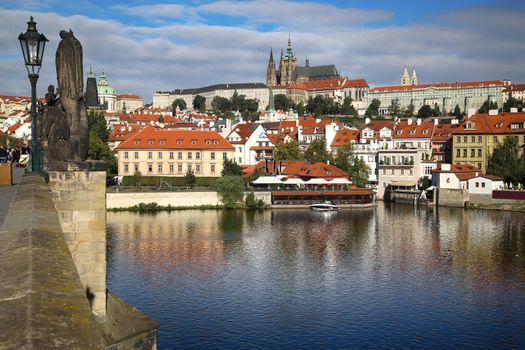 Panoramic view on St. Vitus Cathedral from Charles Bridge with statues on the Bridge Karluv Most in Prague, Czech Republic