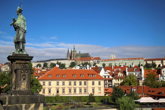 Panoramic view on St. Vitus Cathedral from Charles Bridge with statues of St. John of Nepomuk in Prague, Czech Republic