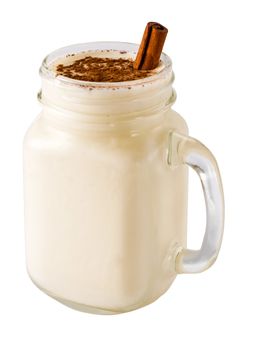 Homemade eggnog with cinnamon in mason jar isolated on white. Eggnog with spices - cinnamon and cinnamon stick - in mason jar isolated with clipping path