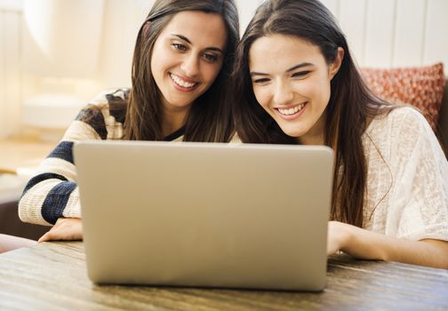 Two young women working on notebook