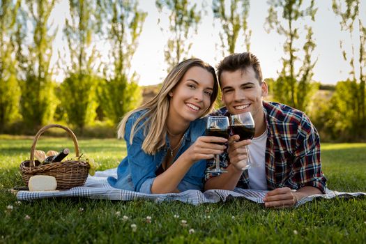 Shot of a beautiful couple on the park making a picnic and drinking wine