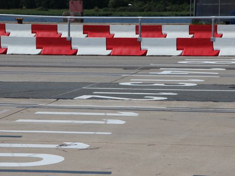 Car Lanes at Ferry Boarding with Red and White Striped Crash Barriers