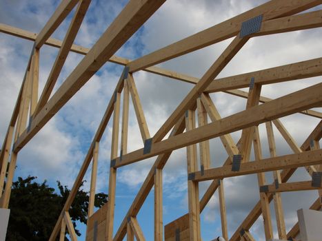 Roof Rafter Construction on Building Site with Sky and Clouds