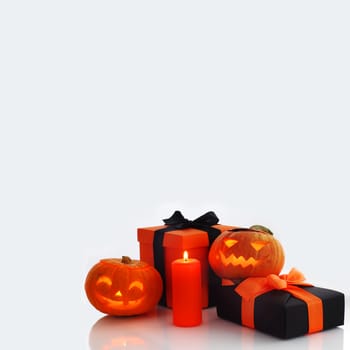 Halloween pumpkin and gifts on gray background
