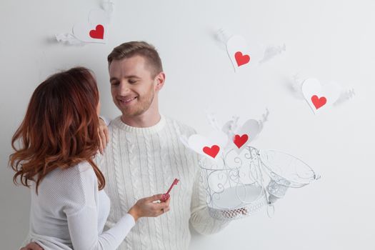 Couple releasing love, man and woman open cage with winged hearts, valentines day concept