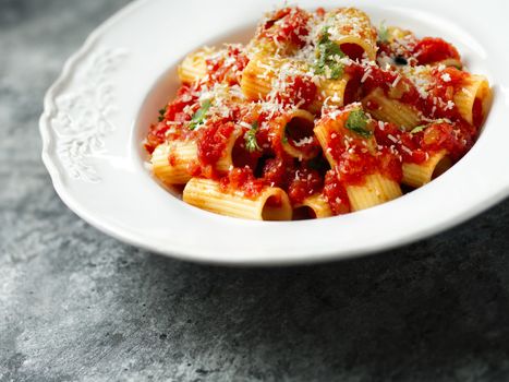 close up of rustic italian rigatoni pasta in tomato sauce