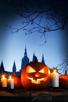 Halloween card with pumpkin and candles, gothic castle and trees silhouette on background