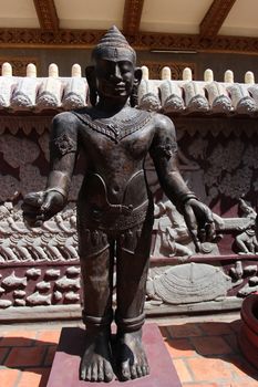 Buddhist sculpture, illuminated by the sun against a wall with relief