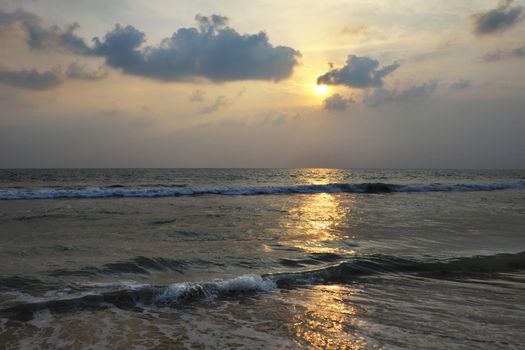 Sunset on the Arabian Sea with the reflection of the sun on the wet sand