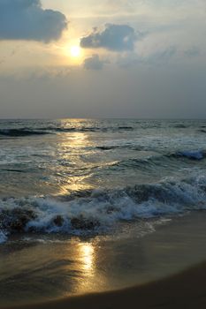 Sunset on the Arabian Sea with the reflection of the sun on the wet sand