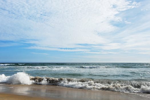 Indian Ocean in calm sunny weather with small waves and clouds