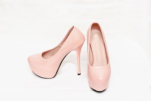 Female pink shoes with high heels isolated against white background.