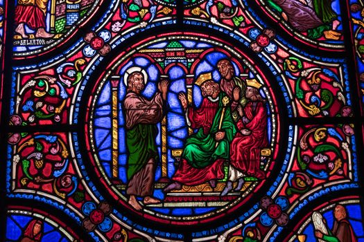 a stained glass church window depicts saints
