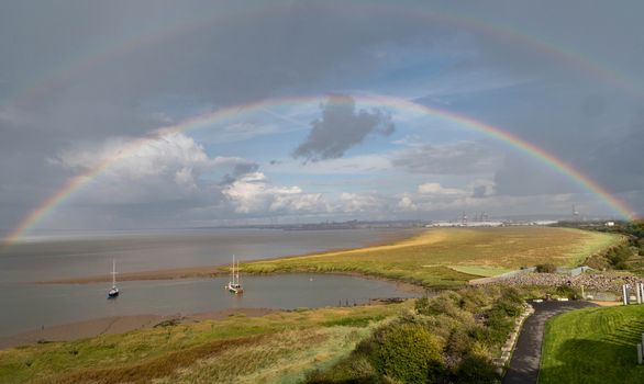 a rainbow arches over yachts moored on the Bristol channel