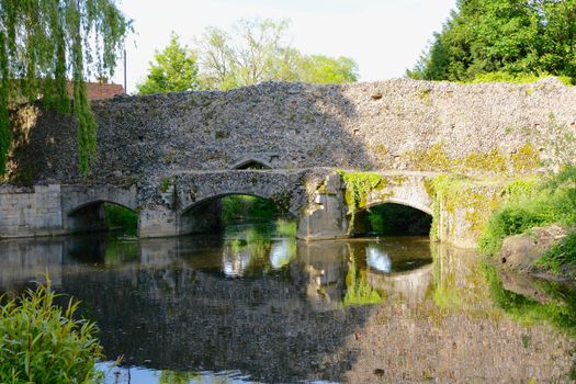 an old bridge of stones over a river in Bury st Edmunds