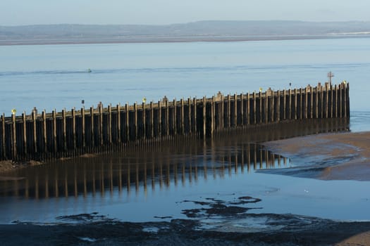 a disused jetty on the sea shore with mudflats