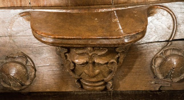 The ancient Green Man carved in a pew seat in a cathedral