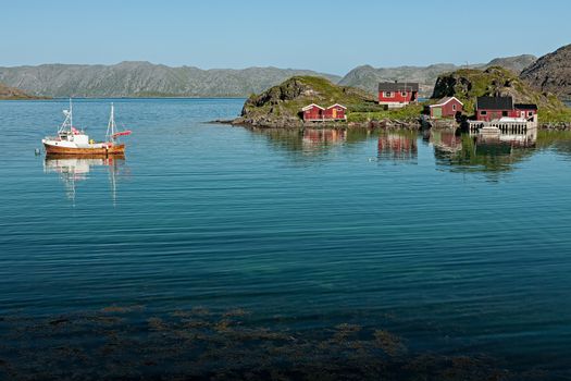 Small norwegian wooden houses and boat near Honningsvag, Norway