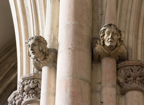 heads carved from stone on a church wall