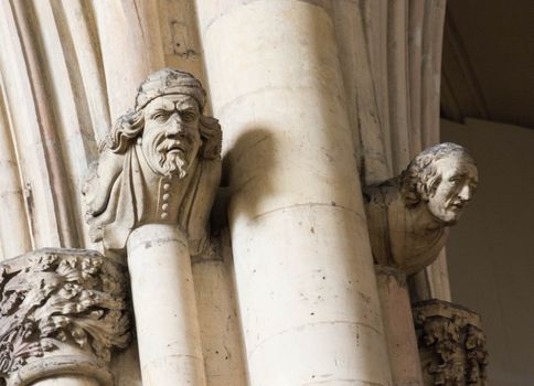 heads carved from stone in a church wall