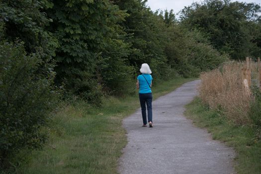 a woman walks down a countryside path