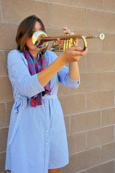 Female jazz trumpet player with her horn outside.