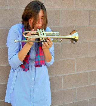 Female jazz trumpet player with her horn outside.