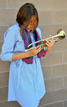 Female jazz trumpet player with her horn outside.