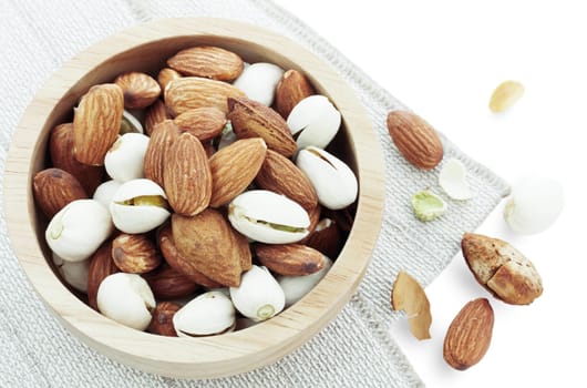 Almond mixed in a bowl on tablecloth.