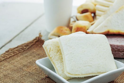 Bread baked in a plate and coffee on table.