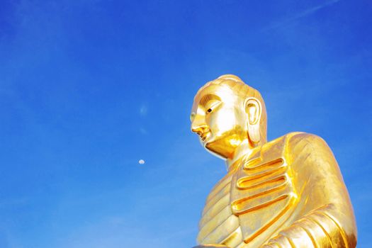 Buddha with the blue sky of background.