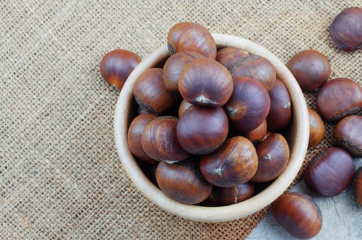 Chestnuts roasted in a bowl on sack.