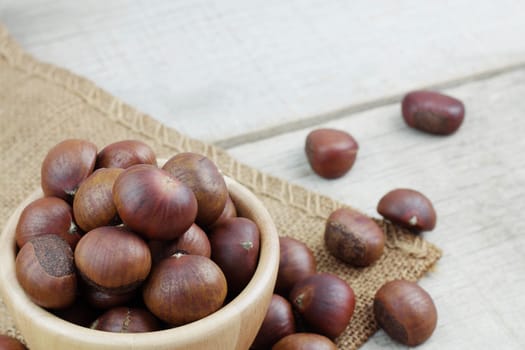 Chestnuts roasted in a bowl on sack.