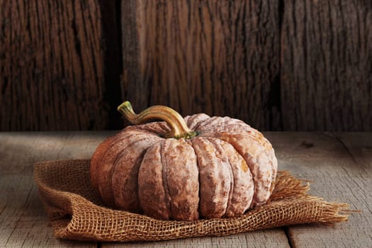 Pumpkin on sackcloth with a wood background.