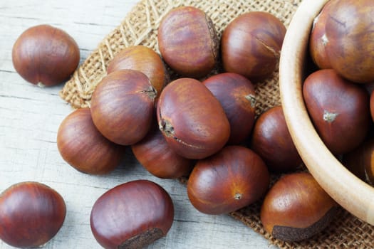 Roasted chestnuts on sackcloth and wooden floor.