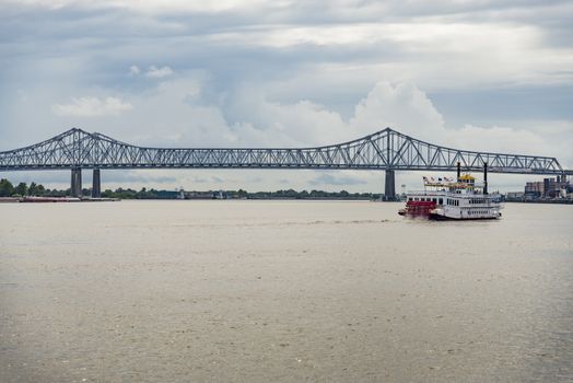 bridge over the Mississippi river with a boat in New Orleans, LA