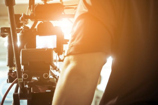 Cameraman with his video camera shooting, Hands Adjusting Camera,film production crew,behind the scenes background.