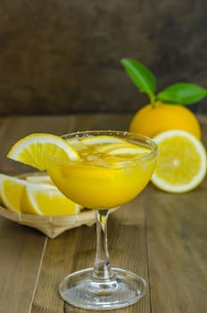 Fresh orange juice on wooden table over grunge background