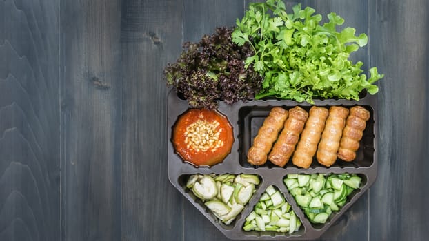 top view of roasted pork served with spicy sauce and vegetable (Nam Neung) on wooden background