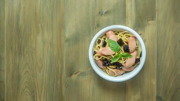 Spaghetti with sausage  and dried peppers , hot and spicy on wooden background, top view