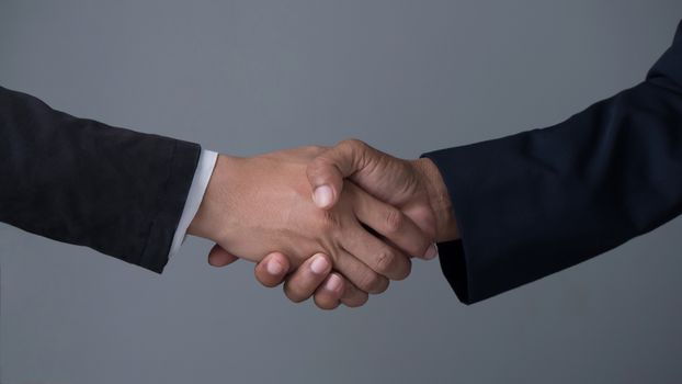 Image businessman handshake , Hand holding on gray background